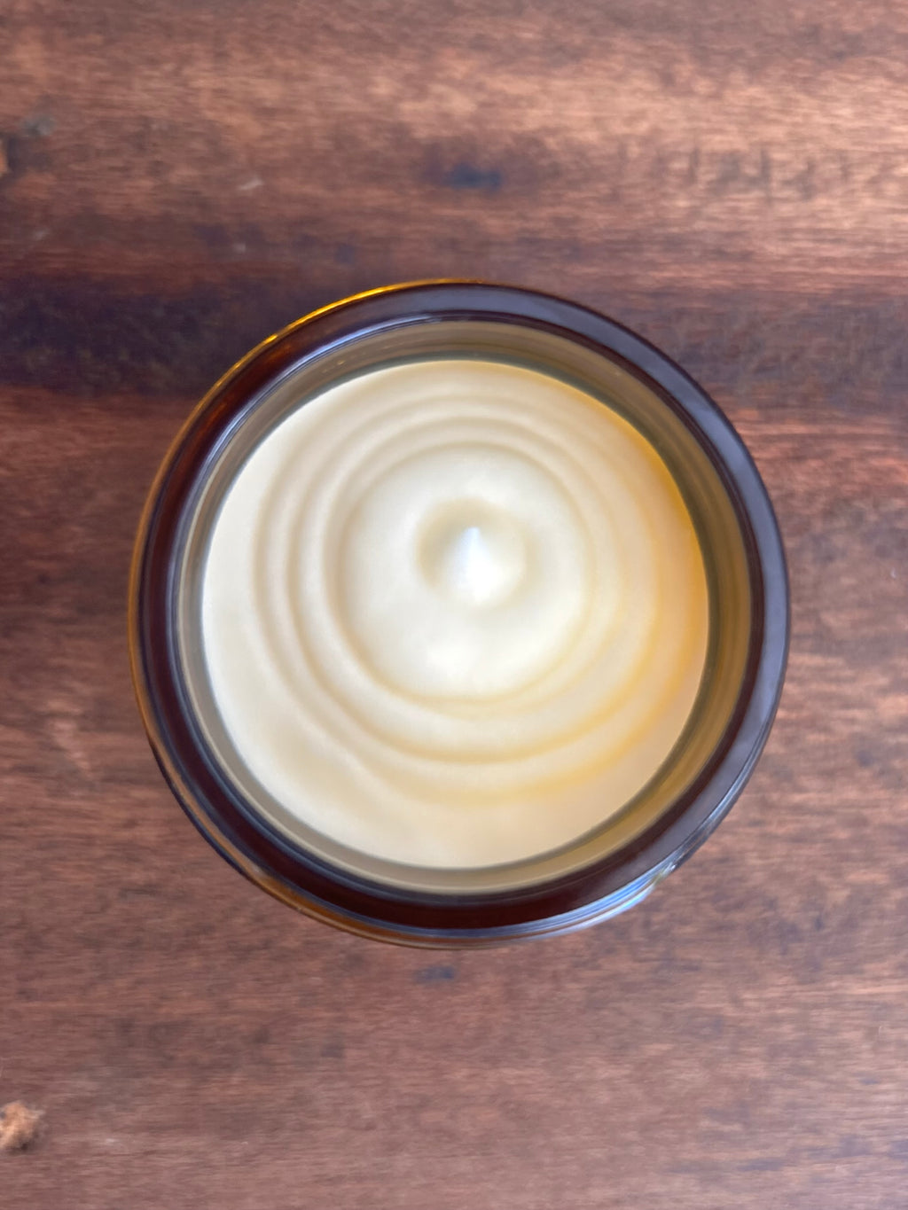Close-up of natural tallow balm texture swirled in an amber glass jar