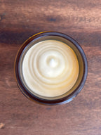 Close-up of natural tallow balm texture swirled in an amber glass jar
